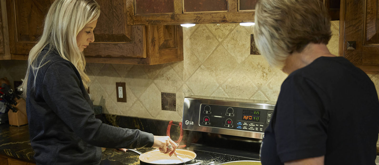 Shali standing in the kitchen cooking dinner with her mom.